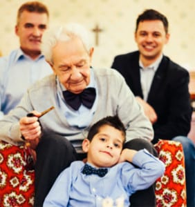 Photo of four generations in a family with a cross in the background